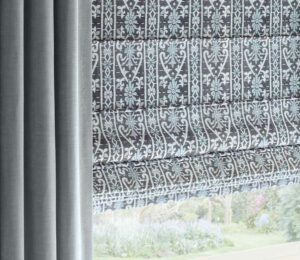 plush blue drapes framing blue and gray and white patterned roman shades