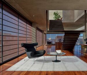 Contemporary loft apartment with maroon window shades and cherry wood accents