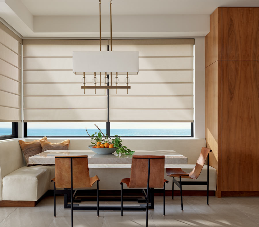 dining area with corner windows with architectural roller shades halfway lowered