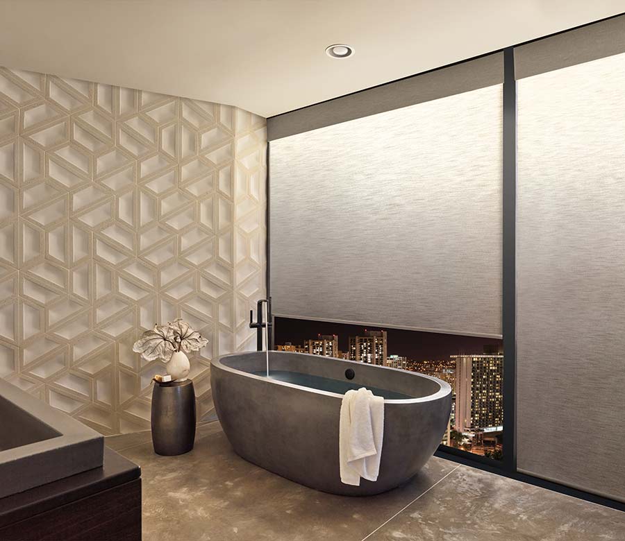 a modern bathroom with a tub next to large windows covered by illuminated privacy shades