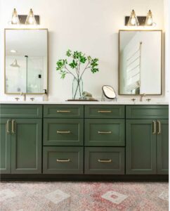green bathroom with brass hardware and rectangle mirrors