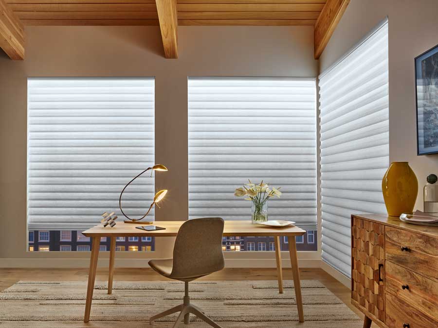 Vignette® Modern Roman Shades in aura backlighting window shades. These are located in a modern office in neutral colors.