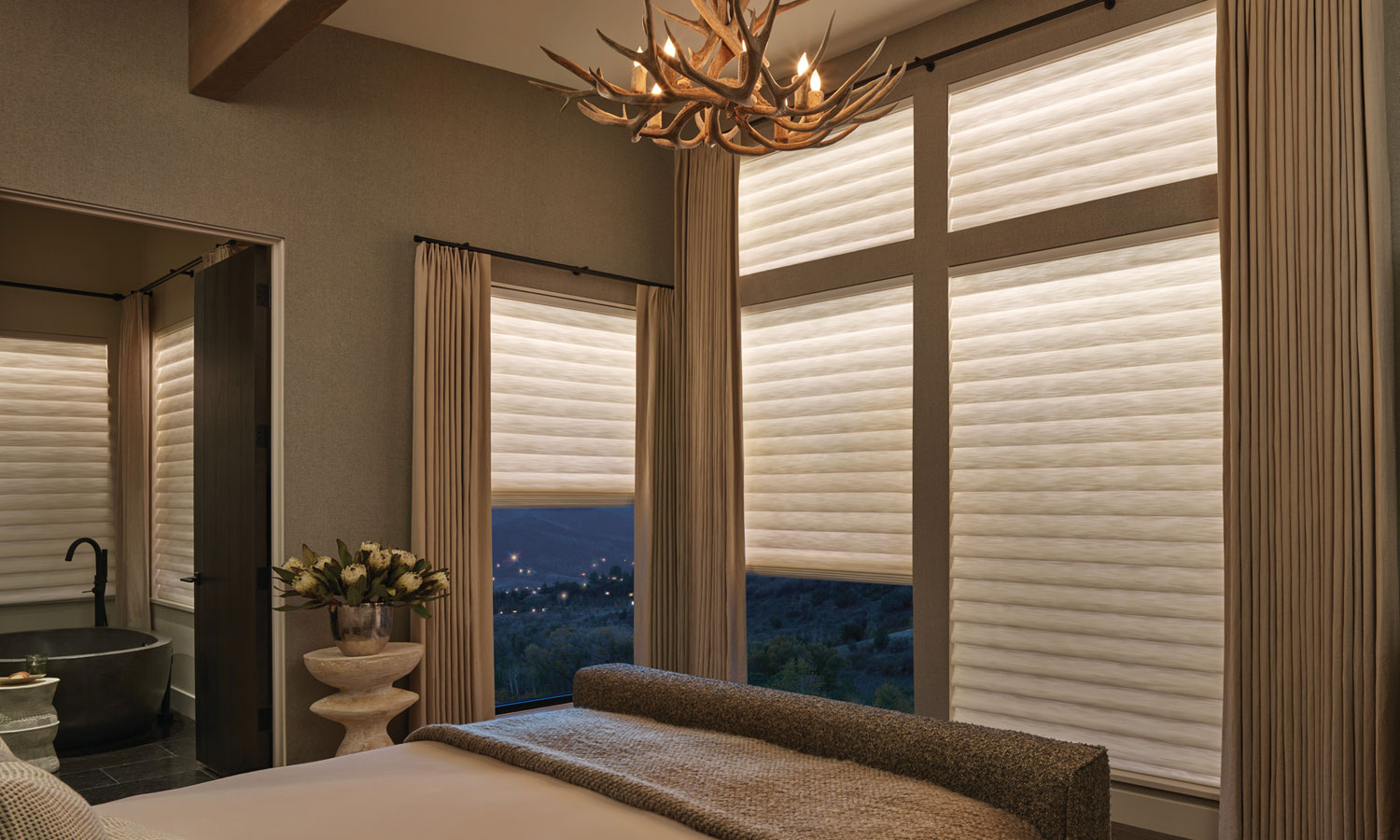 warm lit bedroom with aura illuminated shades by hunter douglas