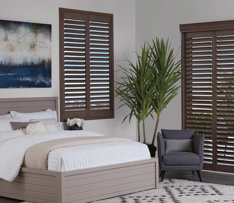 hunter douglas interior shutters in dark brown stain color for sliding door and windows of Omaha area bedroom