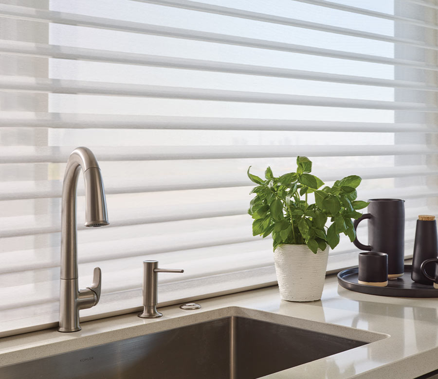 kitchen sink with window behind it covered by window shade