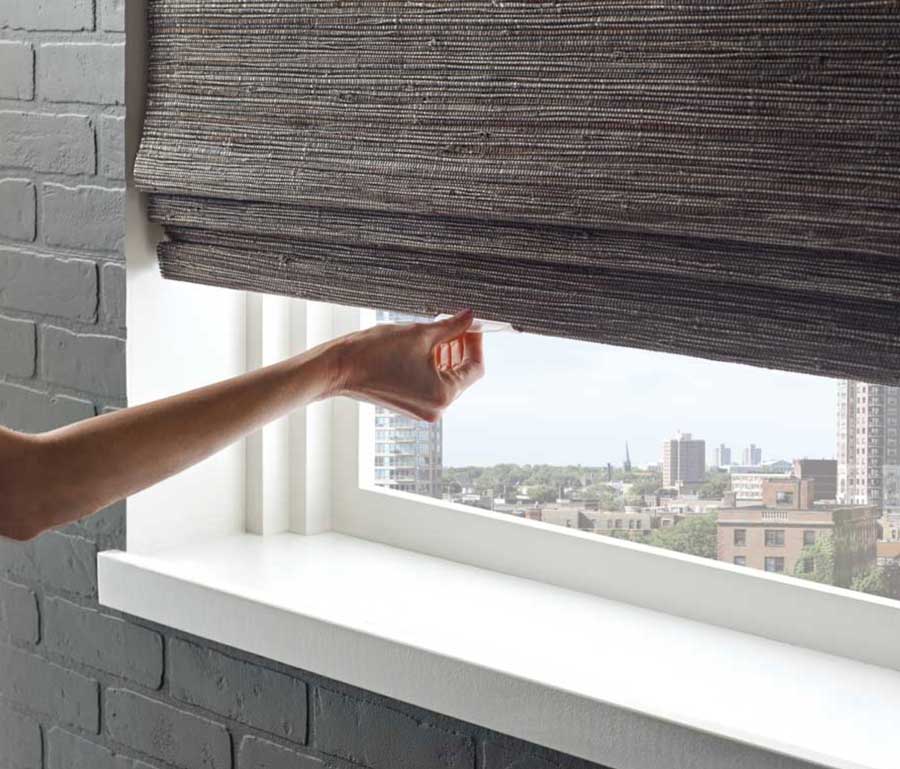 cordless shades being closed by a hand