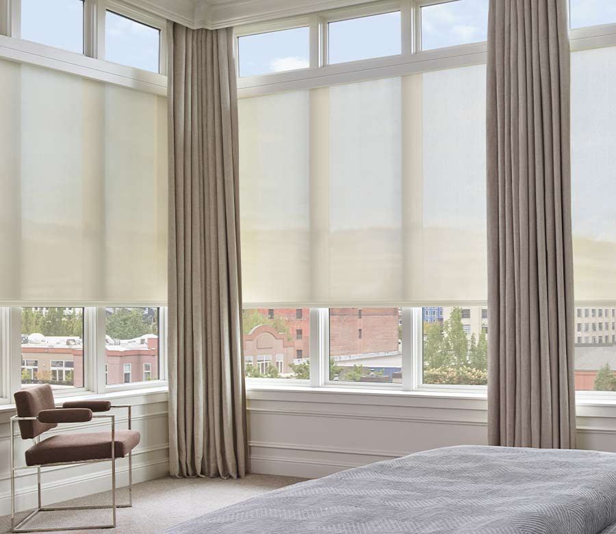 beige bedroom drapes layered over solar shades on large windows